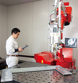 ファイバーレーザ溶接システム「FLW-6000ENSISe」のティーチング作業を行う小坂さん