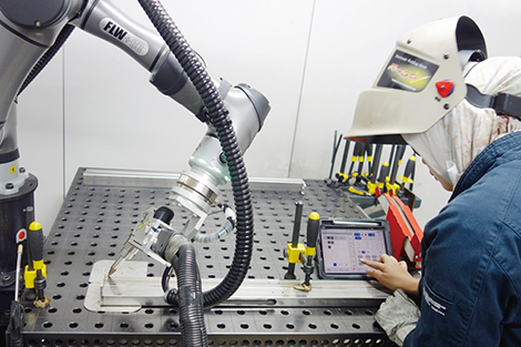 専用ソフト搭載のタブレット端末でティーチングを行うインドネシア人の特定技能外国人の女性