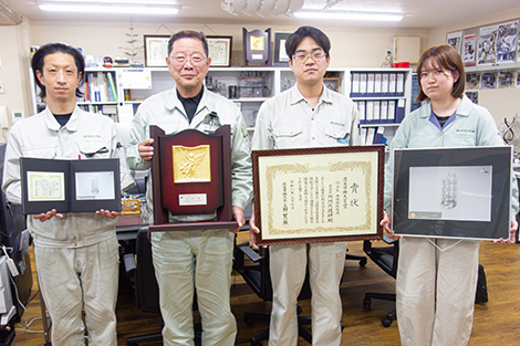 左からレーザ加工担当の田宮真人さん、西田元昭社長、西田庄吾専務、西田有希さん